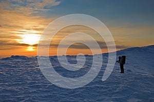 Trekker silhouette at sunset in the mountains