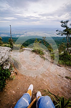 Trekker sitting on the mountain with Beautiful Sunrise and sea of mist in the morning on Khao Luang mountain in Ramkhamhaeng Natio