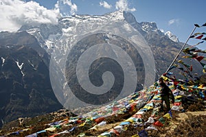 Trekker standing in prayer flags in Nepal Everest region