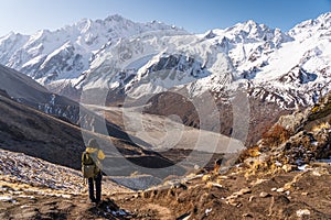 A trekker standing on top of Kyanjin Ri view point and taking picture of Langtang mountain range, Himalaya mountains range in