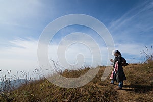 Trekker use mobile phone on mountain peak
