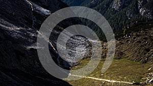 Trekkers dwarfed by mountain scenery, walking in the distance on