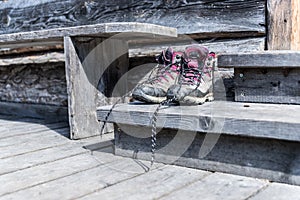 Trekking boots on the veranda of an alpine hut. Summer holidays in the mountains