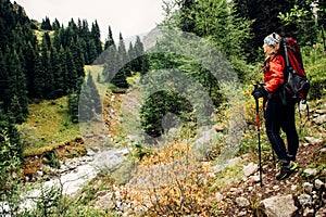 Trekking in the mountains. The girl on the shore of a mountain river.