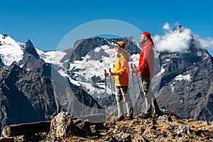 Trekking and Nordic walking. Young couple doing Nordic walking in the mountains. Active rest on the nature.