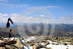 Trekking poles on a snowy summit of a mountain with a great view