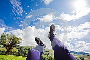 Trekking shoes on the legs over idyllic landscape