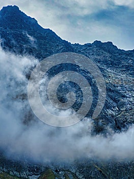 Trekking on snow mountain. Cloudy day in green mountains. Carpathian mountains shot from drone at sunset. View from helicopter.