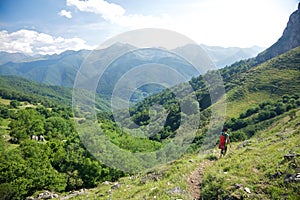 Trekking woman down valley in Picos de Europa