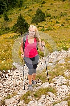 Trekking - woman hiking in mountains on a calm sumer day