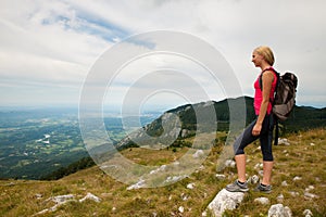 Trekking - woman hiking in mountains on a calm sumer day