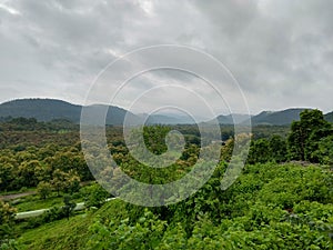 Tremendous green valley view with foggy mountains in the background in monsoon season at Central India photo