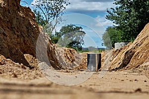 The trench for laying and installation of water pipes.Reinforced concrete well covered with waterproofing mastic, sand rammed base