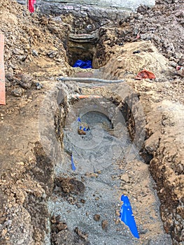 Trench under pavement with hidden water pipes and wires