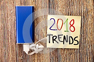 trend 2018 word on sicky note. Empty copy space for inscription. wooden background