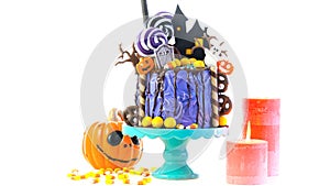 On trend Halloween candyland novelty drip cake on white background. photo