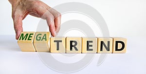 Trend or megatrend symbol. Businessman turns wooden cubes and changes words trend to megatrend. Beautiful white table, white