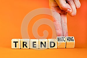 Trend or trendwatching symbol. Concept words Trend and trendwatching on wooden cubes. Businessman hand. Beautiful orange table