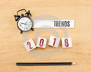 Trends 2018 year on wood cube with pencil and clock top view on wood table,New year business concept.