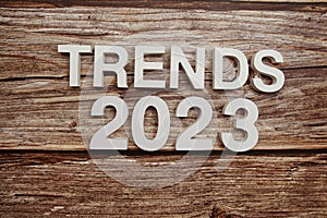 Trends 2023 alphabet letters on wooden background photo