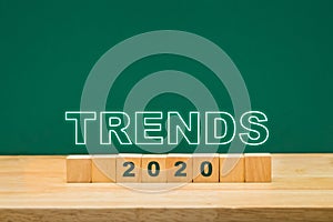 Trends 2020 idea on wood cube block on table with green blackboard.business forecasting concept