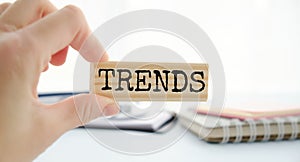 TRENDS text on wooden block with hand