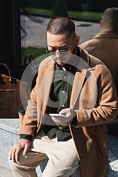 trendy asian man using mobile phone