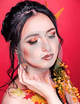 Trendy autumnal makeup . Fashion beauty model girl. Closeup portrait isolated on red background