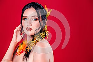 Trendy autumnal makeup . Fashion beauty model girl. Closeup portrait isolated on red background with copy space