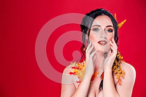 Trendy autumnal makeup . Fashion beauty model girl. Closeup portrait isolated on red background with copy space