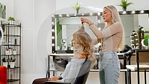 Trendy barber stacks girl hair in barbershop.