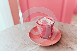 Trendy beetroot latte with latte art and flower petals