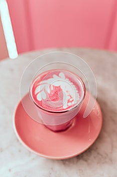 Trendy beetroot latte with latte art and flower petals