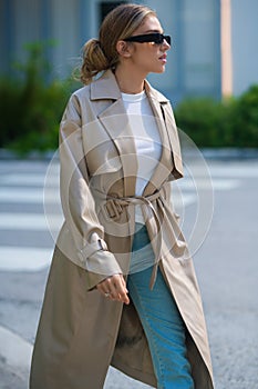 Trendy coat. High fashion model walking on city street. Girl fashion style. Fashion beautiful elegant woman. Young woman
