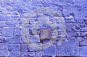 Trendy Color of the year 2022 Very Peri. Brick background grunge texture. Stone lilac brick wall. Wall of an old ruined brick