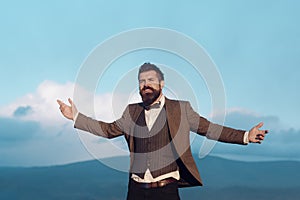 Trendy cool young man standing outside smoking cigarette, wearing shirt against blue sky