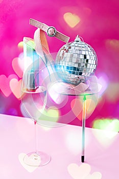 Trendy creative photo of Champagne glass with white wine and high heels in a modern balancing composition. Party concept.