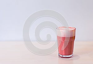 Trendy drink, pink berry coffee latte with foam on table on white background. Copy space for menu.