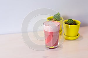 Trendy drink, pink strawberry coffee latte on table on white background. Copy space for menu