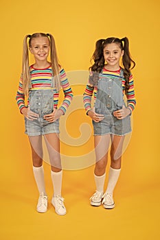 Trendy and fancy. Little girls wearing rainbow clothes. Matching outfits. Fashion shop. Must have accessory. Vibrant