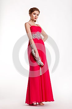 Trendy fashion model in long red dress posing