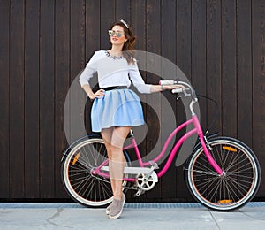 Trendy Fashionable Girl with Vintage Bike on Wooden Background. Toned Photo. Modern Youth Lifestyle Concept.