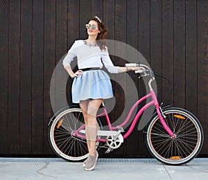 Trendy Fashionable Girl with Vintage Bike on Wooden Background. Toned Photo. Modern Youth Lifestyle Concept.