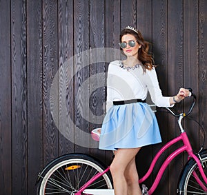 Trendy Fashionable Girl with Vintage Bike on Wooden Background. Toned Photo. Modern Youth Lifestyle Concept. Close up.