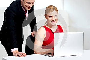 Trendy female boss working with man assisting