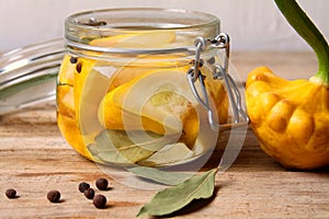 Trendy Fermented vegetables buch pumpkin patisson in glass jar on wooden table.