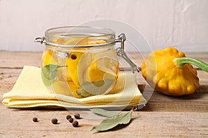 Trendy Fermented vegetables buch pumpkin patisson in glass jar on yellow napkin on wooden table.