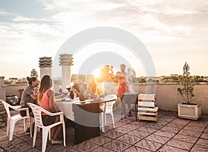 Trendy friends having barbecue party on top of the roof - Happy people doing bbq dinner outdoor - Main focus on woman with yellow