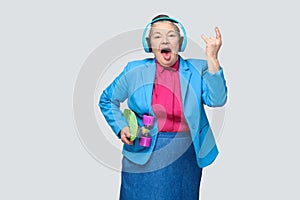 Trendy funny grandmother in casual style with blue headphones ho