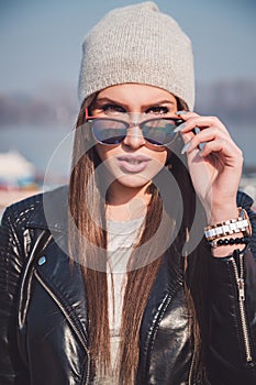 Trendy girl with attitude holding sunglasses